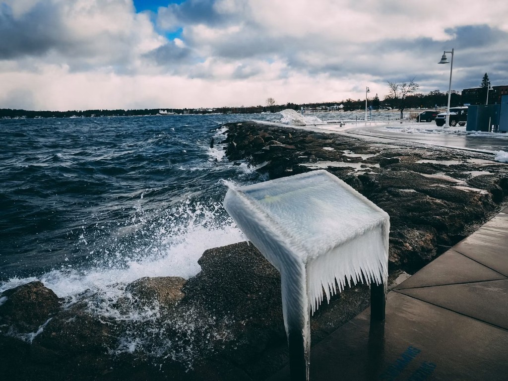 Iced shoreline sign and winter waves on Lake Michigan