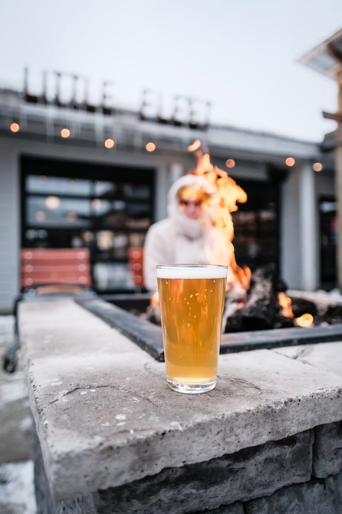 Pint glass by a fire pit at Little Fleet in Traverse City