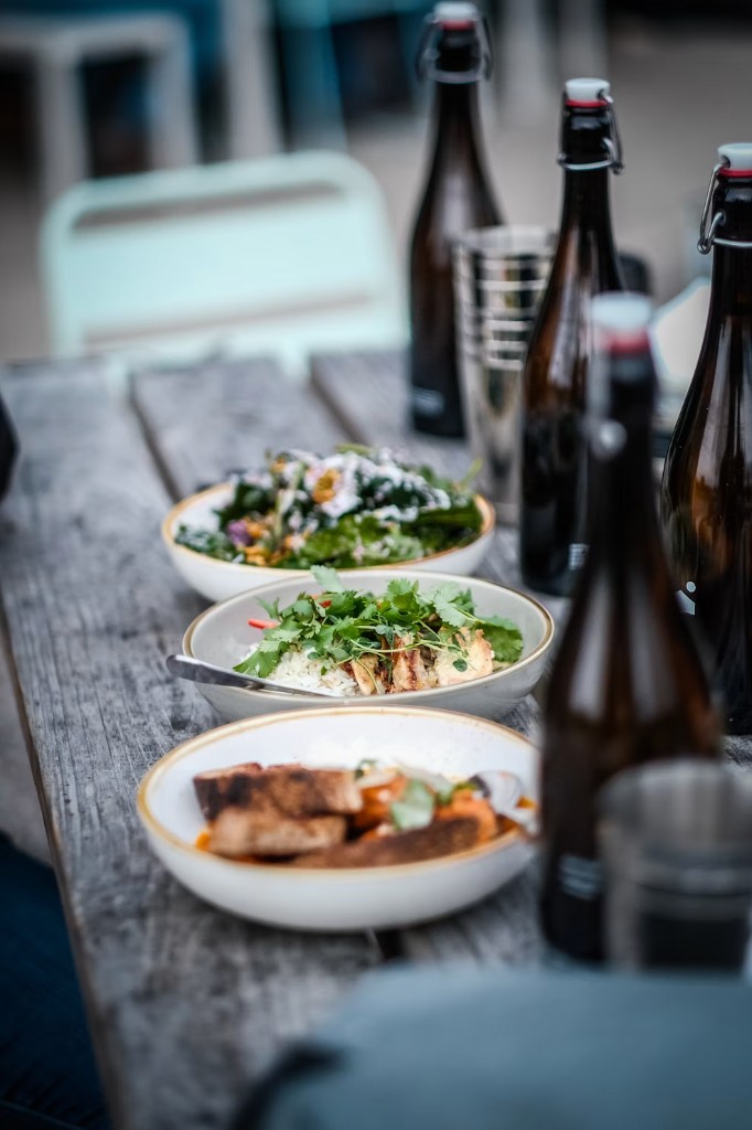 Communal table with bowls of food and bottles